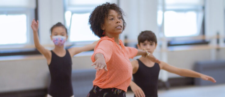 a female instructor leading young dancers in a studio