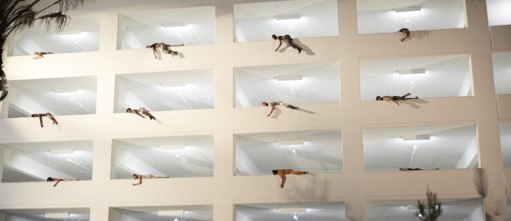a large parking garage with dancers hanging over the side of each opening